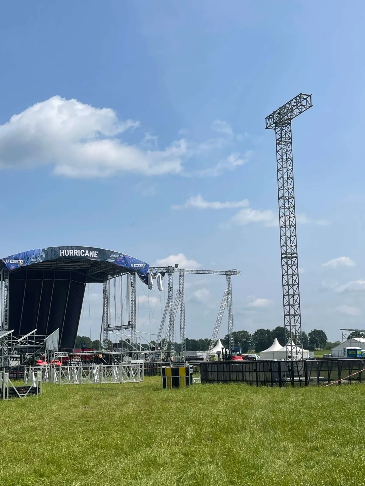 Festivalbühne mit Hurricane-Banner und Lichtmast auf einer Wiese