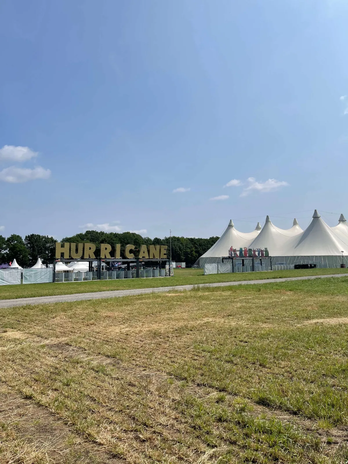 Festivalgelände mit Hurricane-Schriftzug und weißen Zelten