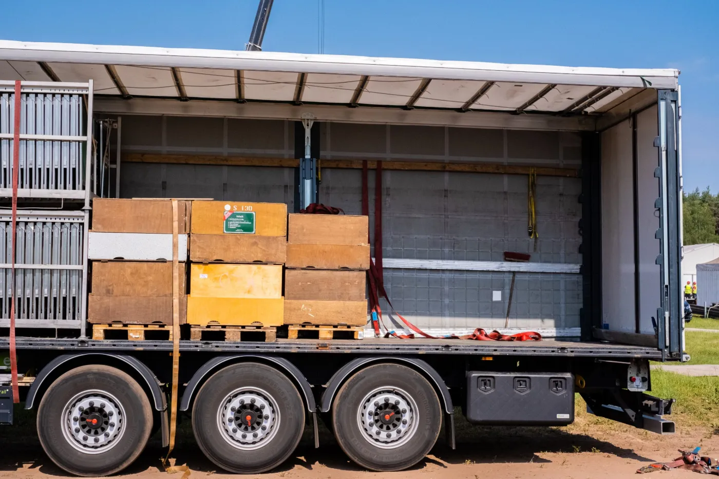 Offener Lkw-Auflieger mit Holzkisten auf Paletten