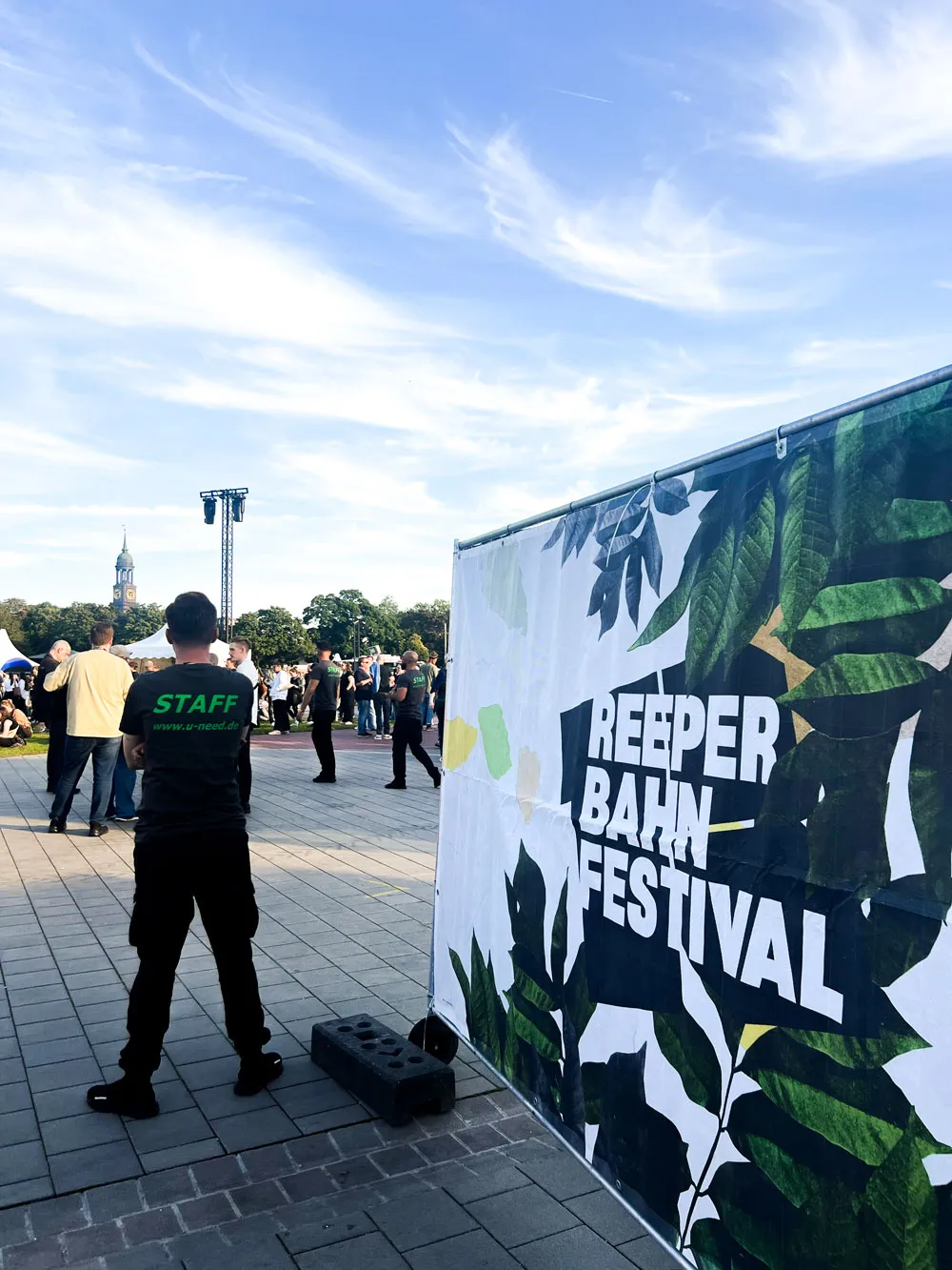 Staff von hinten neben einem Banner des Reeperbahn Festivals