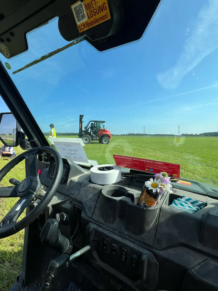 Blick aus einer Fahrerkabine auf einen Geländestapler auf dem Festivalgelände