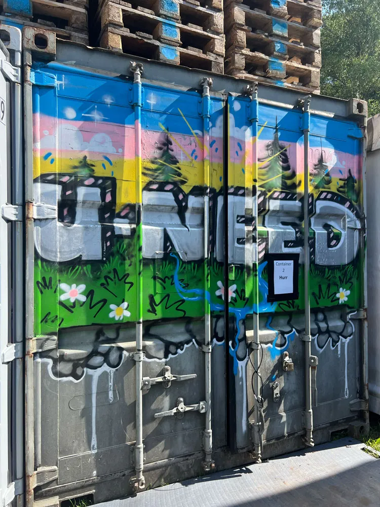 Container mit buntem U-Need-Graffiti