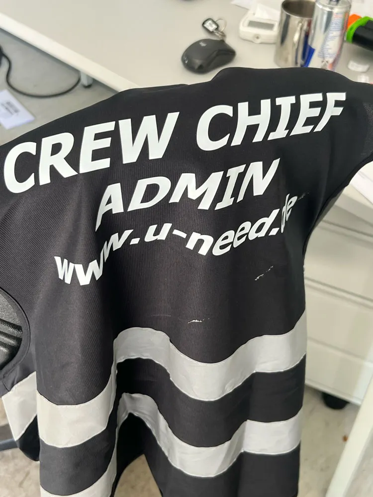 Schwarzes Oberteil mit Reflexstreifen und der Aufschrift Crew Chief Admin