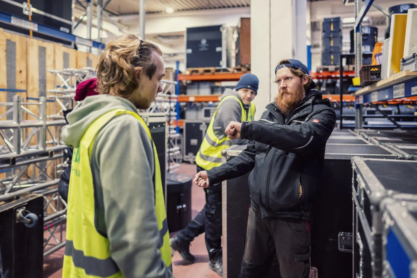 Crew bei einer Schulung im Lager zwischen Traversen und Flightcases